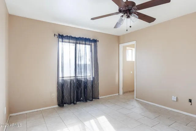 an empty room with fan and windows