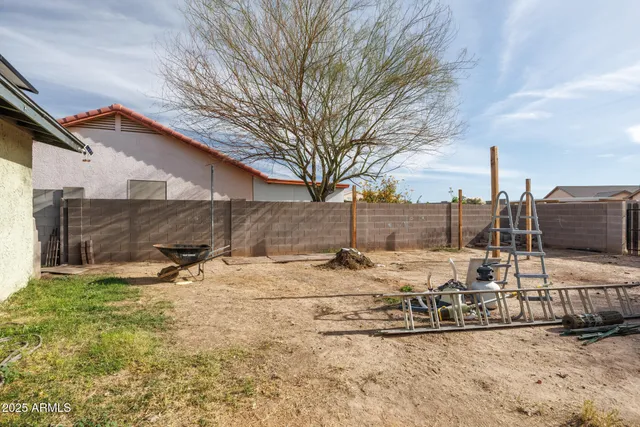 a view of a house with backyard and a tree