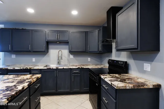 a kitchen with granite countertop a sink stove and cabinets