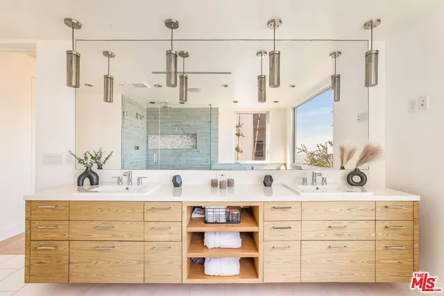 a bathroom with a double vanity sink mirror and shower