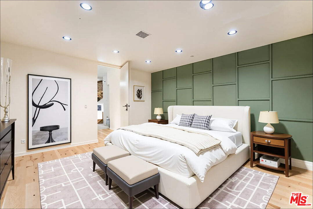 1610 Viewmont Drive Los Angeles, CA 90069 - Photo 13 of 22 a bedroom with a bed a mirror and paintings on the wall