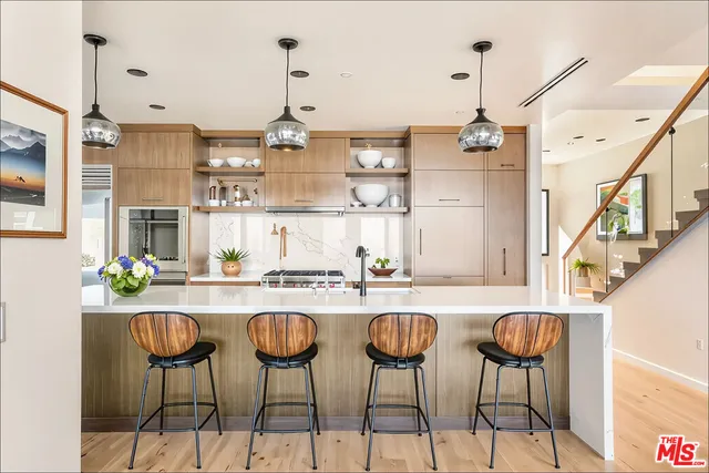 a kitchen with stainless steel appliances kitchen island granite countertop a table and chairs in it