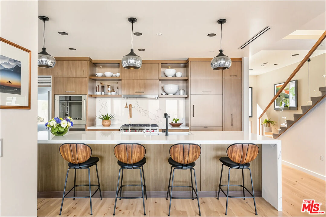 1610 Viewmont Drive Los Angeles, CA 90069 - Photo 6 of 22 a kitchen with stainless steel appliances kitchen island granite countertop a table and chairs in it