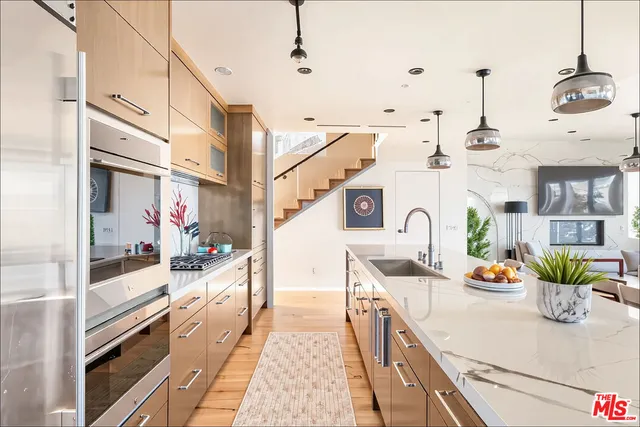 a kitchen with stainless steel appliances kitchen island sink stove and cabinets