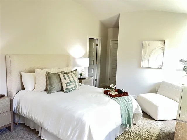 a bedroom with bed a lamp and a couch