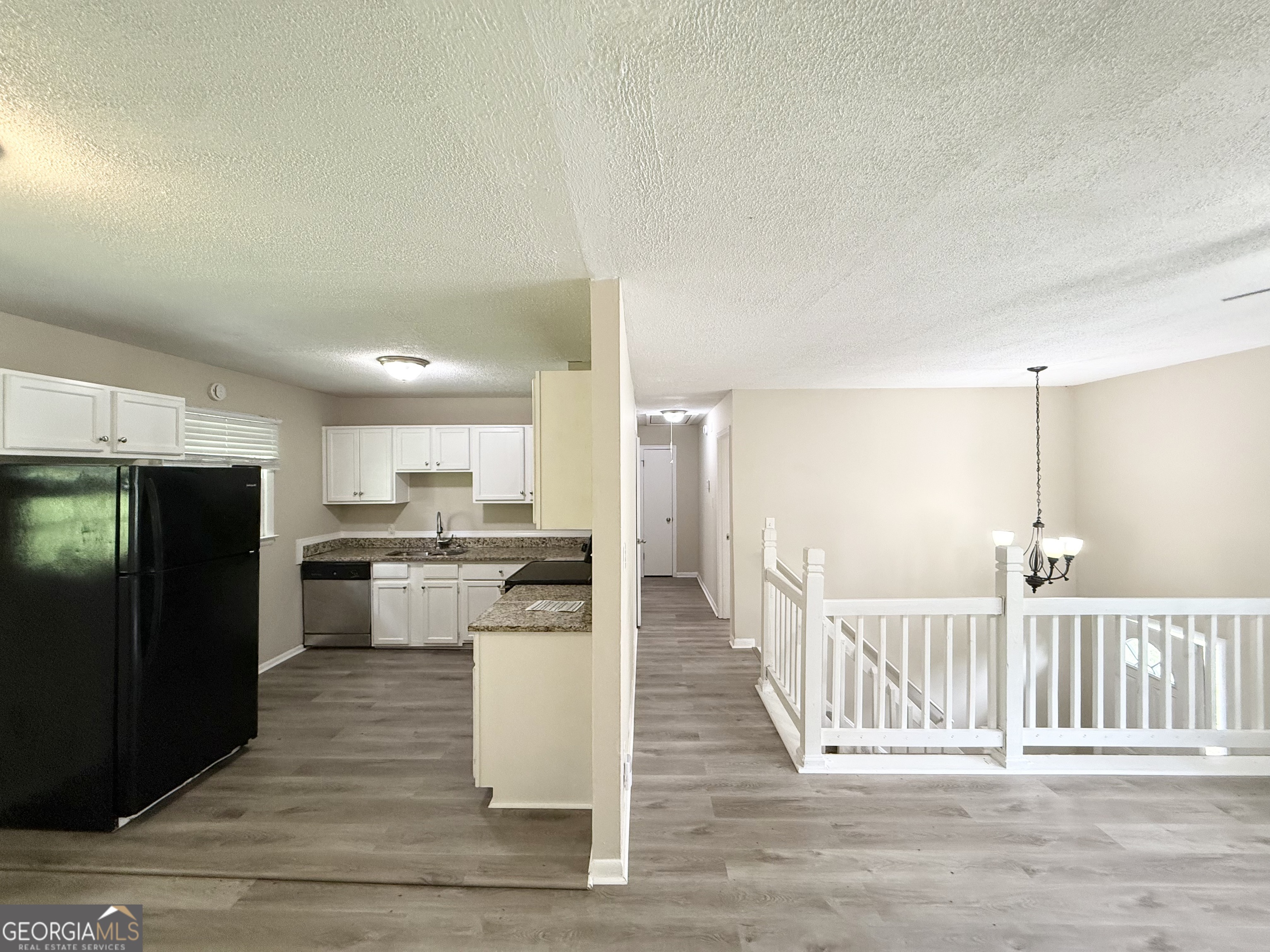 2782 Ocean Valley Road Atlanta, GA 30349 - Photo 7 of 27 a kitchen with stainless steel appliances kitchen island wooden cabinets and refrigerator