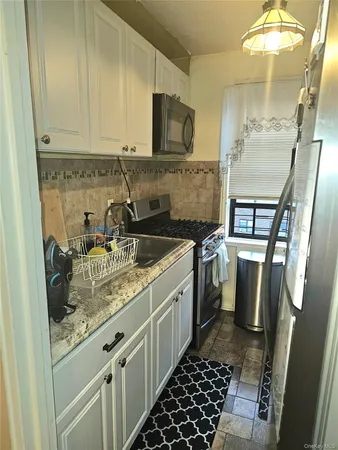 a kitchen with a sink a stove and cabinets