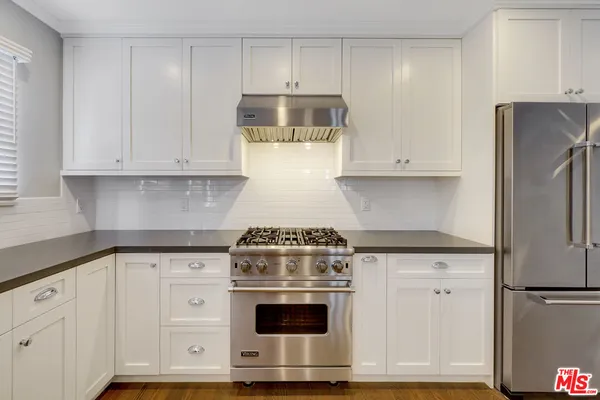 a kitchen with granite countertop white cabinets and white appliances