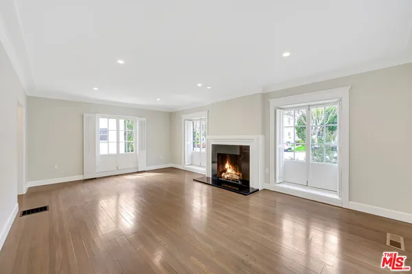 a view of an empty room with window and fire place