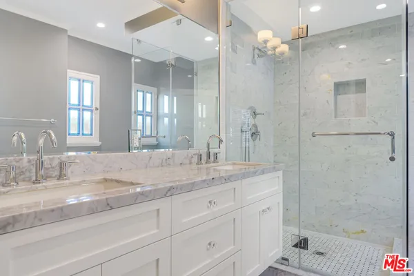 a bathroom with sink shower and mirror
