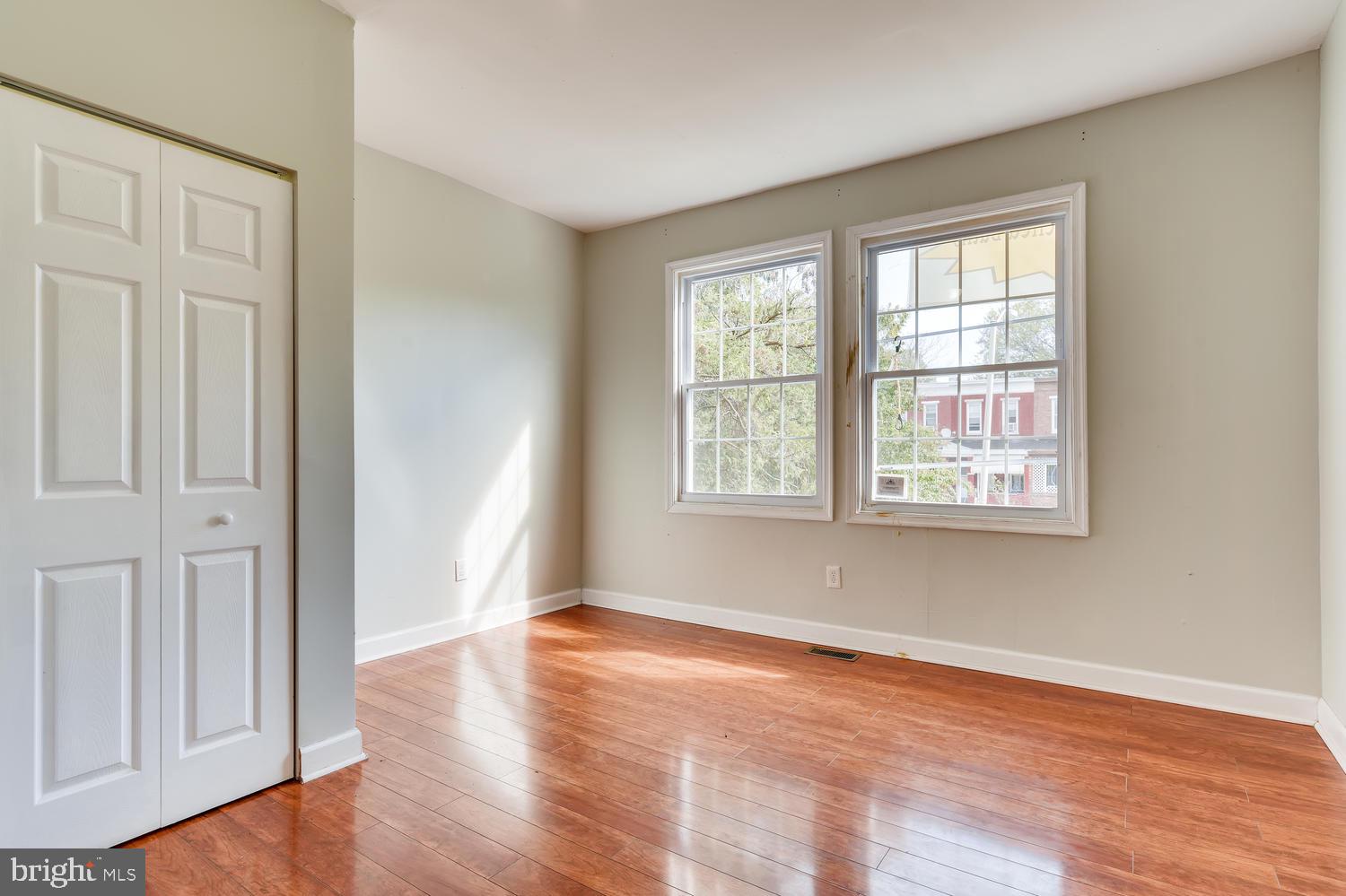 3610 Greenmount Avenue Baltimore, MD 21218 - Photo 11 of 24 an empty room with wooden floor and windows