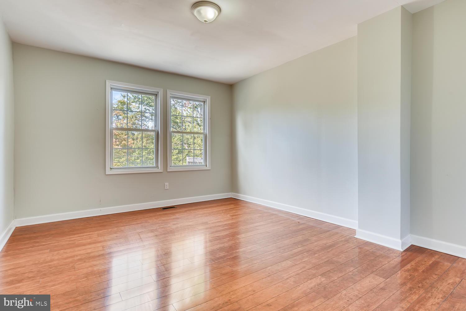 3610 Greenmount Avenue Baltimore, MD 21218 - Photo 16 of 24 an empty room with wooden floor and windows