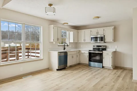 a kitchen with granite countertop a stove a sink and a refrigerator
