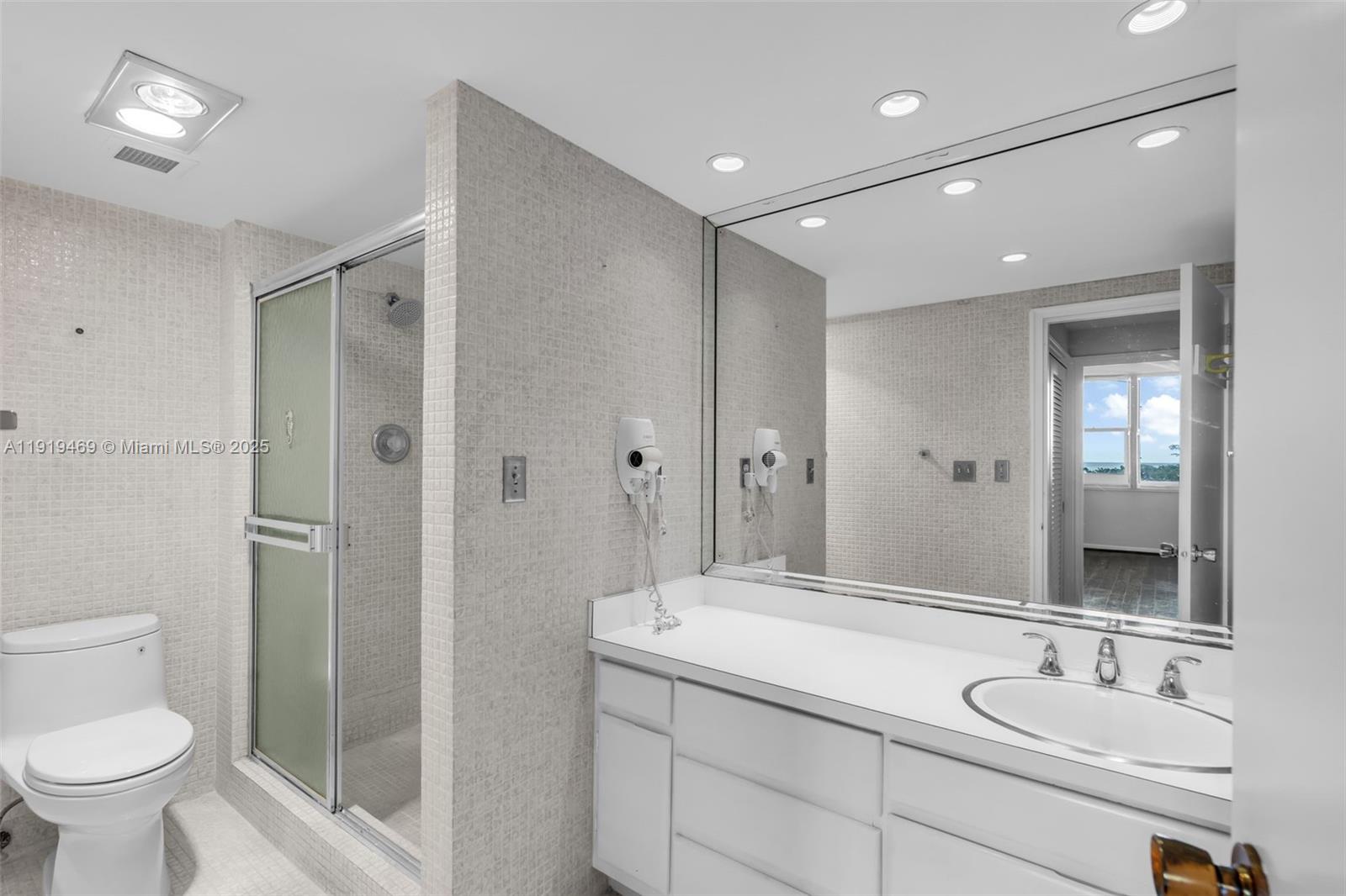 200 Ocean Ln Drive, Unit 407GR09 Key Biscayne, FL 33149 - Photo 22 of 56 a bathroom with a sink toilet a mirror and shower