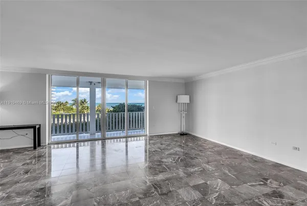 an empty room with floor to ceiling window and wooden floor
