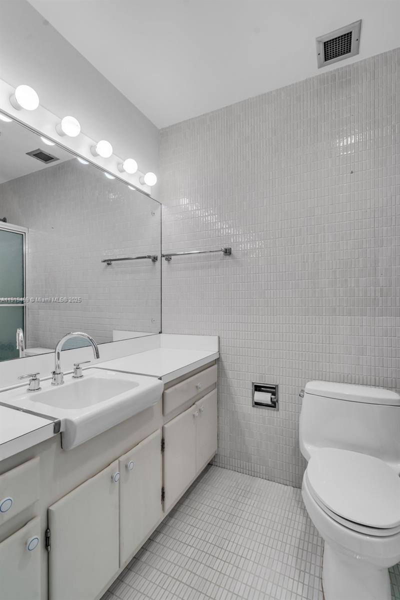 200 Ocean Ln Drive, Unit 407GR09 Key Biscayne, FL 33149 - Photo 33 of 56 a bathroom with a toilet sink and mirror
