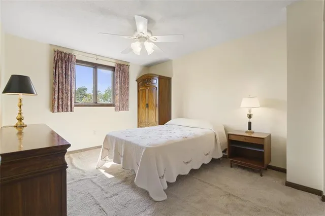 a bedroom with a bed and a lamp on dresser