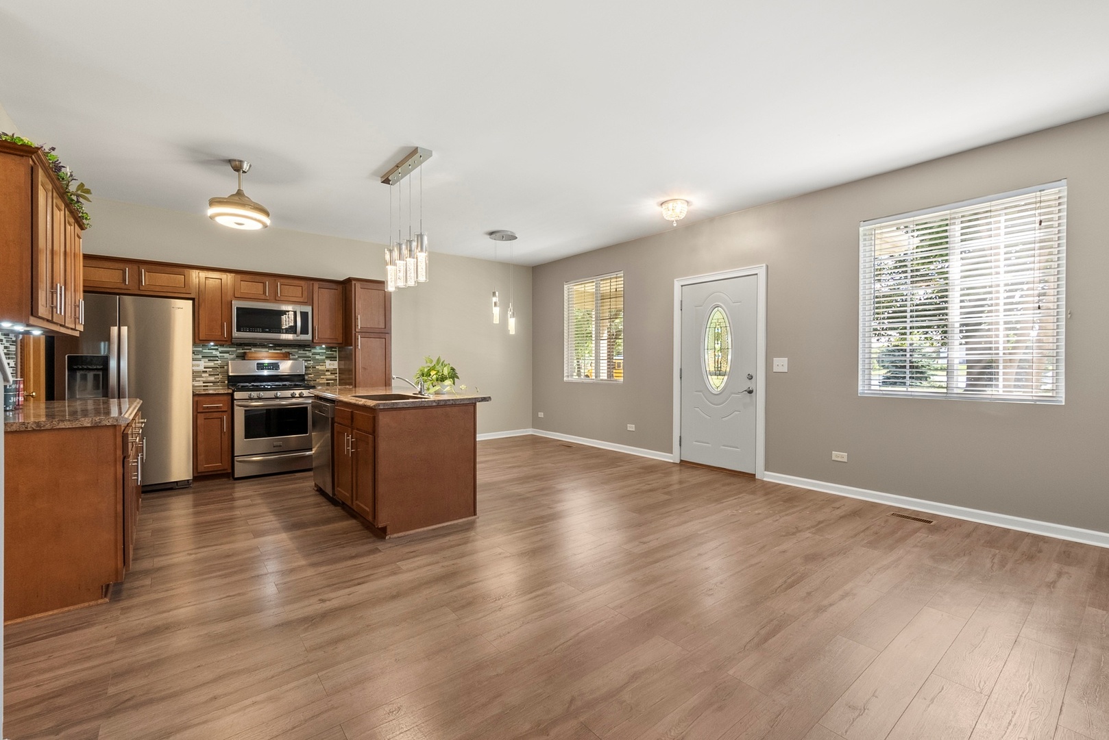 1565 Azalea Circle Romeoville, IL 60446 - Photo 3 of 30 a view of kitchen with kitchen island stainless steel appliances refrigerator stove microwave and cabinets