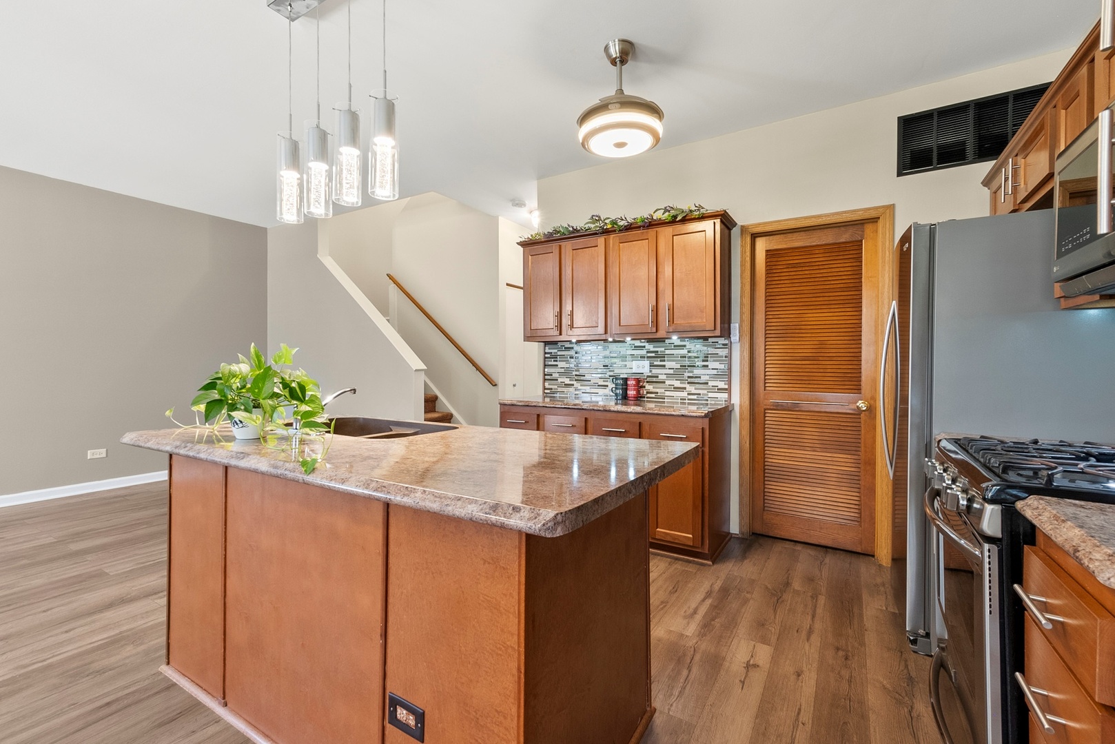 1565 Azalea Circle Romeoville, IL 60446 - Photo 7 of 30 a kitchen with stainless steel appliances granite countertop a sink a stove and a wooden floors