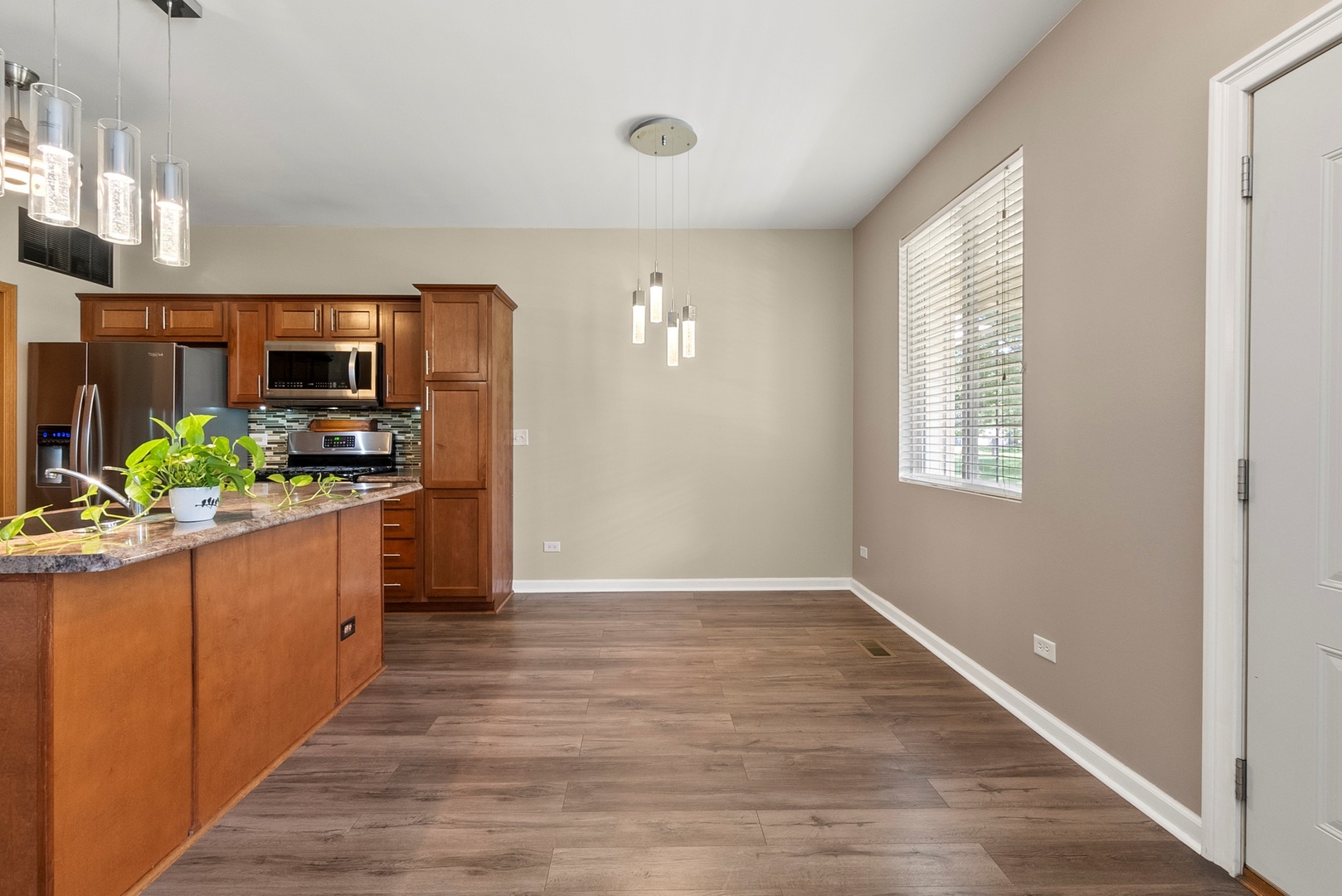 1565 Azalea Circle Romeoville, IL 60446 - Photo 9 of 30 a kitchen with granite countertop a stove and a wooden floor