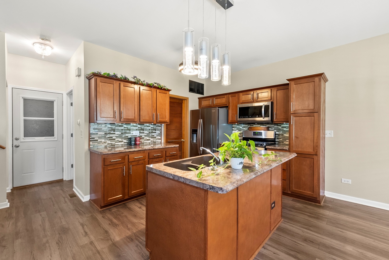 1565 Azalea Circle Romeoville, IL 60446 - Photo 10 of 30 a kitchen with stainless steel appliances kitchen island granite countertop a stove refrigerator and microwave