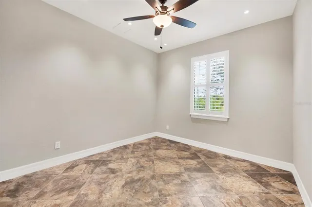 an empty room with a window and a fan