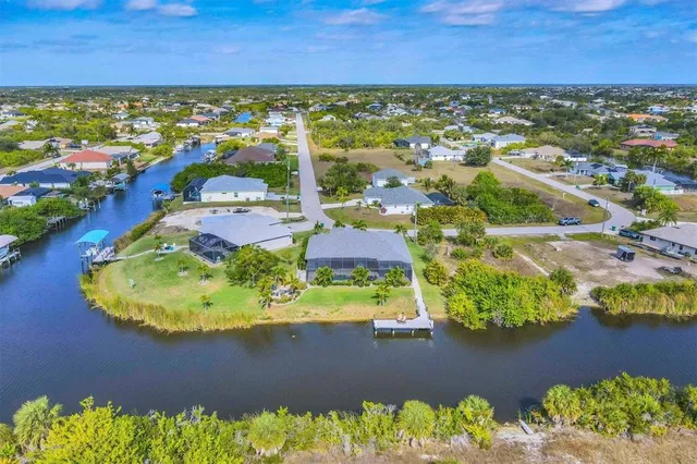 an aerial view of a residential houses with outdoor space and a lake view