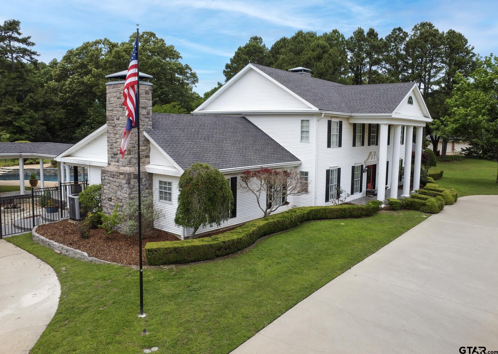 18722 Ridgeline Road Tyler, TX 75703 - Photo 27 of 47 Beautiful landscaping, flagpoles, and a welcoming fountain welcome you home.