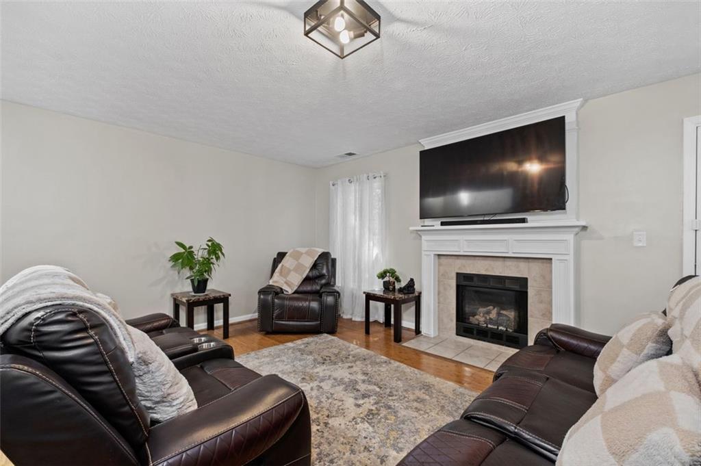 6115 Riveroak Terrace Atlanta, GA 30349 - Photo 18 of 41 a living room with furniture a fireplace and a flat screen tv
