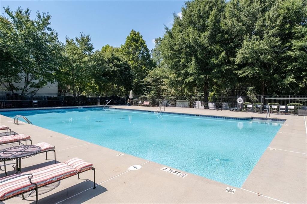 6115 Riveroak Terrace Atlanta, GA 30349 - Photo 41 of 41 a view of a backyard with lawn chairs potted plants and a palm tree