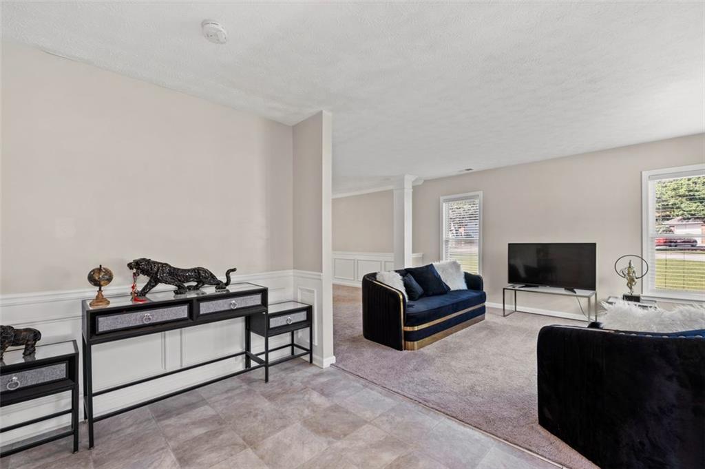 6115 Riveroak Terrace Atlanta, GA 30349 - Photo 6 of 41 a living room with furniture and a flat screen tv