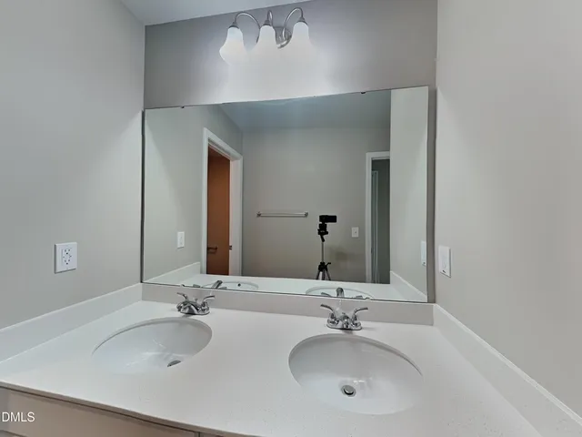 a bathroom with double vanity sinks and a mirror