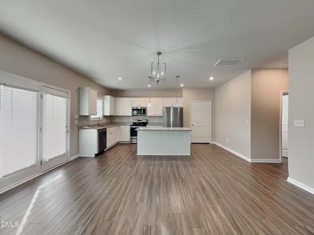 a view of kitchen with wooden floor and electronic appliances