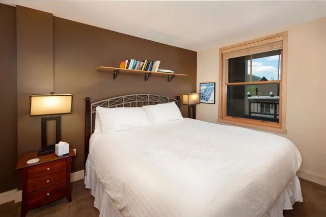 a large bed sitting in a bedroom and a lamp