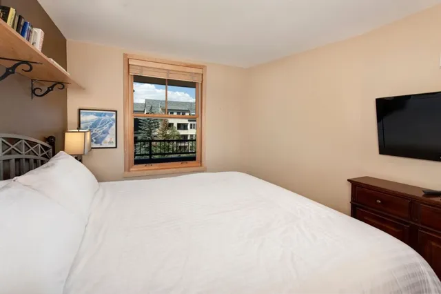 a bedroom with a bed and a flat screen tv