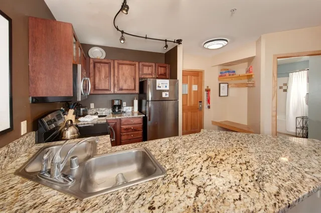 a kitchen with a refrigerator sink and cabinets