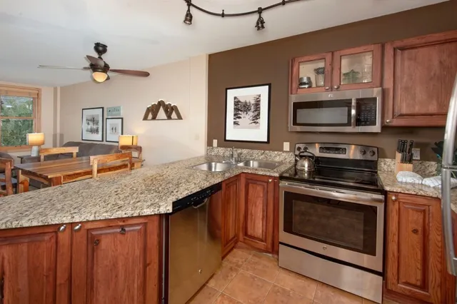a kitchen with stainless steel appliances granite countertop a stove microwave and cabinets