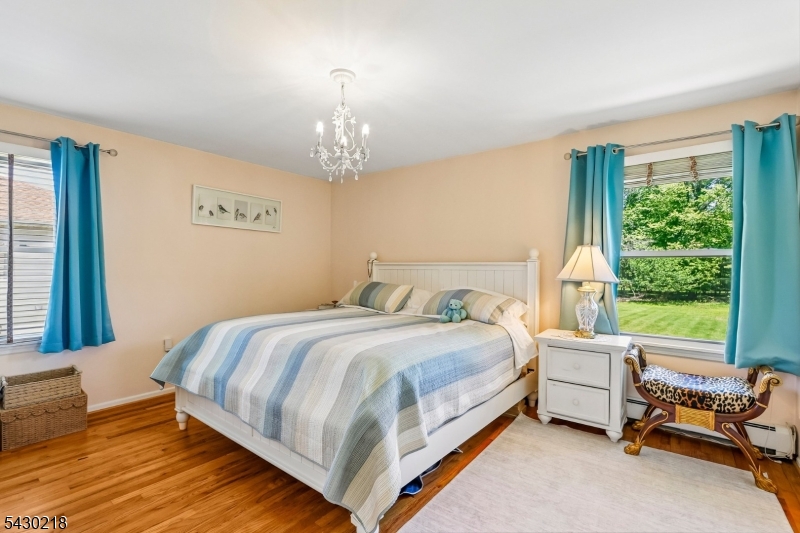 718 New Dover Road Edison, NJ 08820 - Photo 14 of 22 a bedroom with a bed and a chandelier