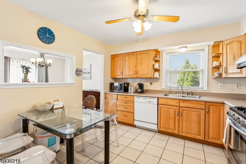 718 New Dover Road Edison, NJ 08820 - Photo 10 of 22 a kitchen with a table chairs and white cabinets