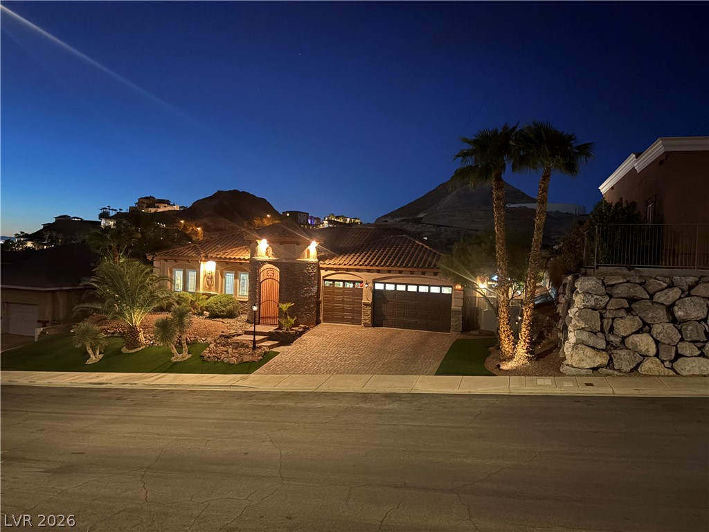 Dramatic mountain backdrops frame this meticulously landscaped desert estate under the evening sky.