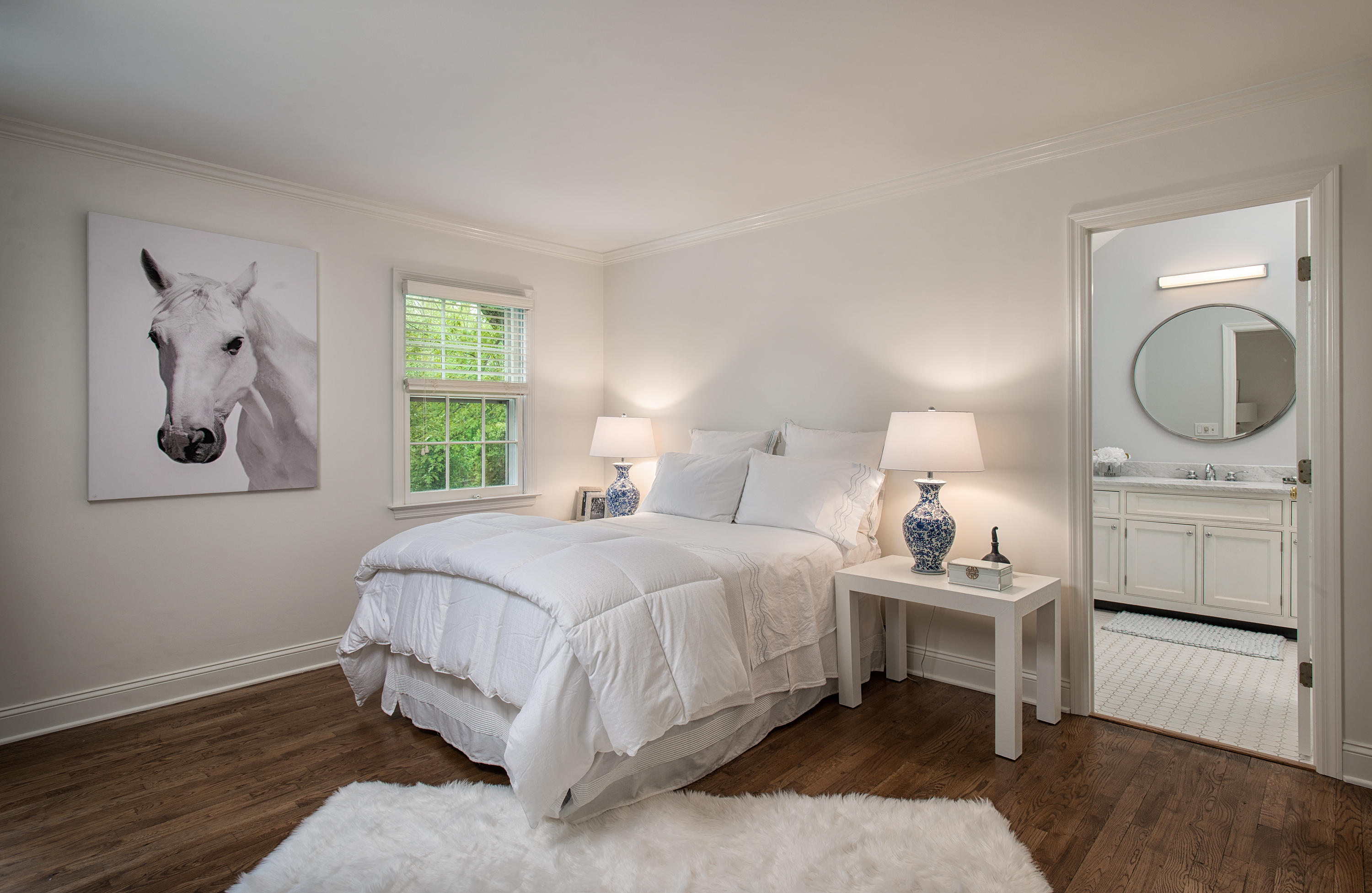104 Logan Road New Canaan, CT 06840 - Photo 19 of 34 a bedroom with a bed a mirror and a window