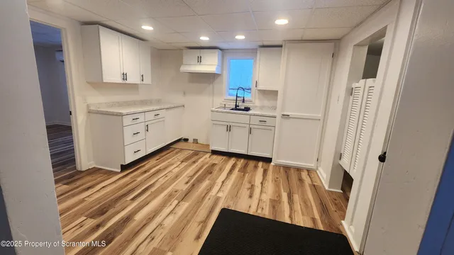 a kitchen with a sink window and cabinets