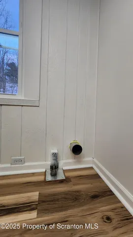 a view of water heater room with wooden floor