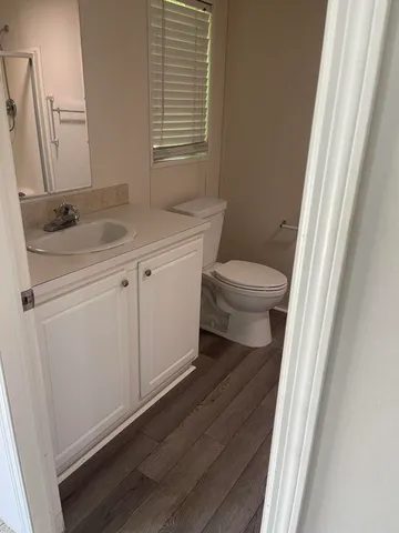a bathroom with a sink a toilet and a window