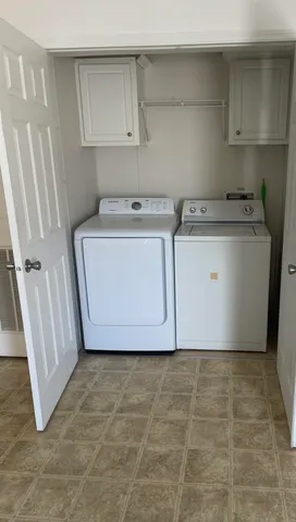 a utility room with cabinets washer and dryer