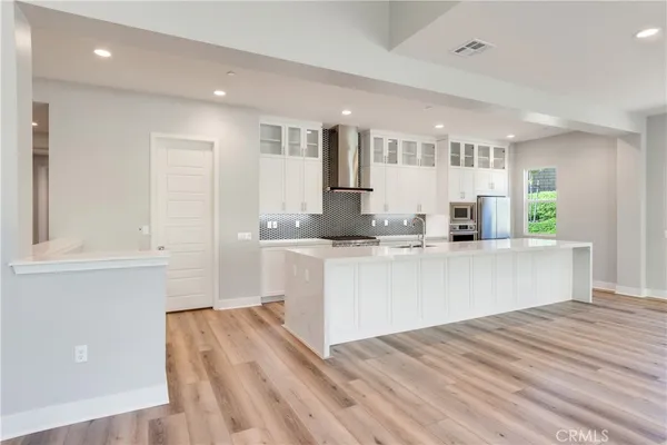 a kitchen with stainless steel appliances granite countertop a refrigerator sink and white cabinets