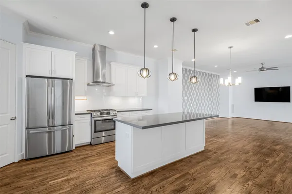 a kitchen with stainless steel appliances granite countertop a refrigerator a stove a sink and a refrigerator