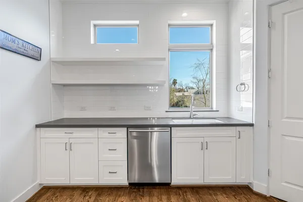 a kitchen with granite countertop a sink and cabinets