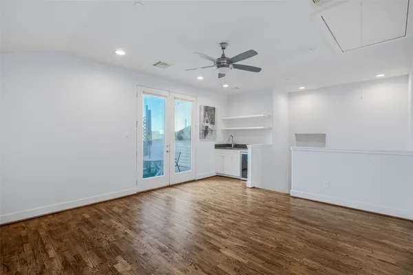 a view of an empty room with window and wooden floor