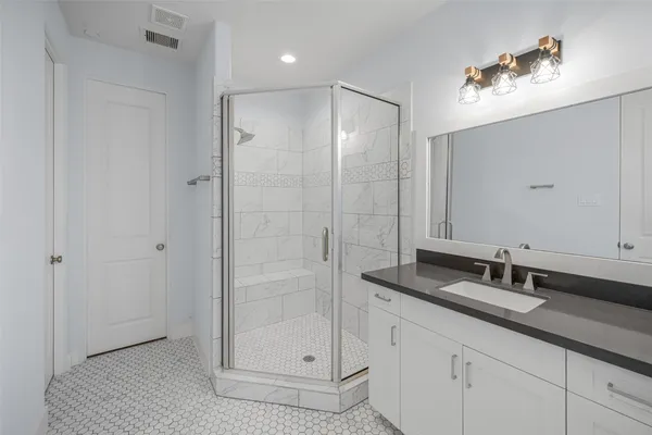 a bathroom with a shower sink and mirror